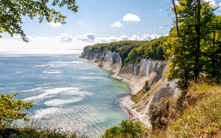 Die Kreidefelsen auf der Insel Rügen an der Ostsee, umgeben von grünen Wäldern und dem klaren blauen Wasser.