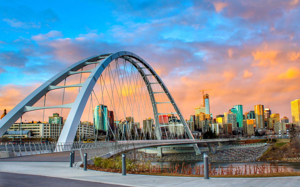 Moderne Bogenbr&uuml;cke mit Blick auf die Skyline von Edmonton bei Sonnenuntergang.
